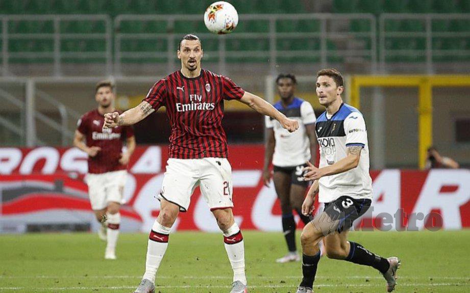Penyerang AC Milan, Zlatan Ibrahimovic (kiri) merebut bola dari pemain Atalanta. FOTO Agensi