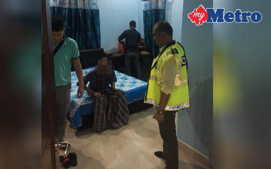 POLIS membuat pemeriksaan di rumah seorang dalang utama  memperdagangkan manusia (duduk) untuk eksploitasi sebagai buruh kasar di Klang, malam semalam. FOTO ihsan PDRM