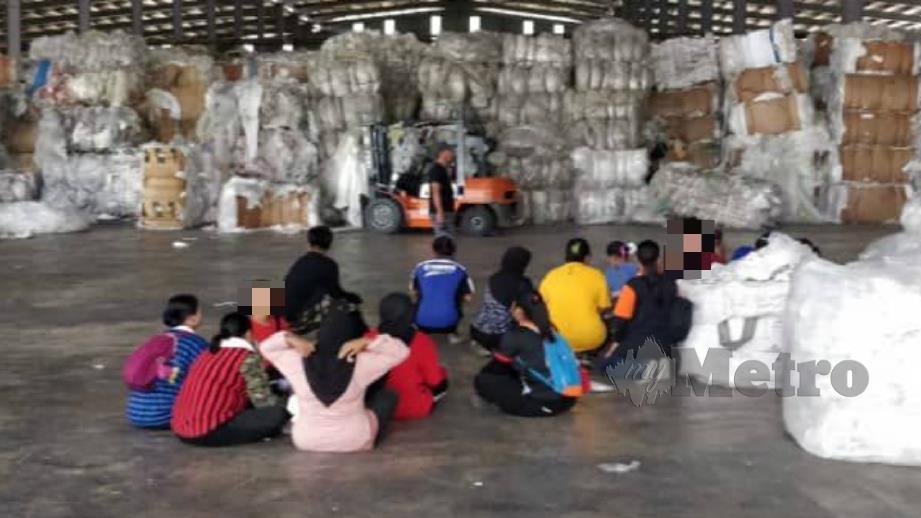 Pekerja kilang kitar semula di Kuang, Rawang diperiksa anggota imigresen dalam operasi kelmarin. Foto Ihsan JIM 