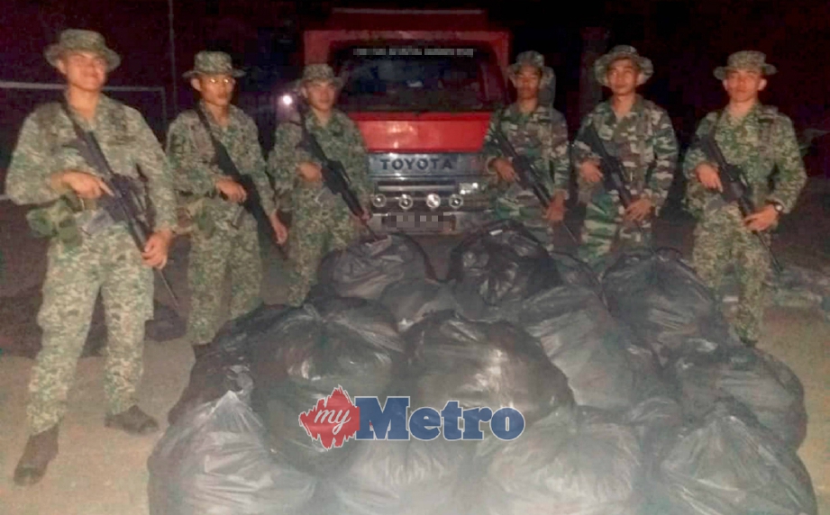 ANGGOTA Pasukan 4 Rejimen Sempadan (4RS) menunjukkan bungkusan daun ketum dirampas dianggarkan bernilai RM55,000 di Pos Sahara, Padang Terap, awal pagi semalam. FOTO ihsan ATM.
