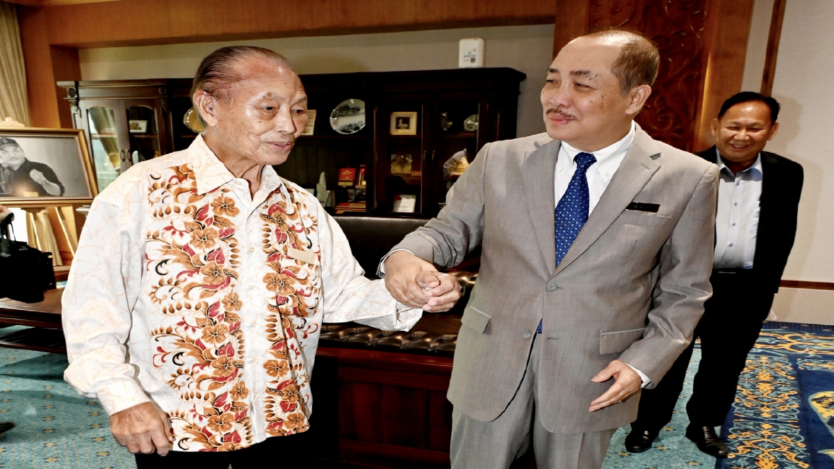 DATUK Seri Hajiji Noor (kanan) memimpin tangan Buatin Blandong semasa menerima kunjungan warga emas itu di pejabatnya di  Menara Kinabalu, Kota Kinabalu di sini. FOTO BERNAMA
