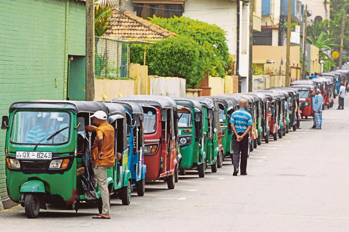 BARISAN panjang kenderaan selepas pengguna cuba mendapatkan bekalan bahan api dari stesen minyak di Colombo. FOTO AFP 