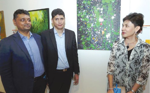 YURI Azzari (tengah) bersama ibu bapanya bergambar dengan lukisannya di pameran Nukilan Jiwa.
