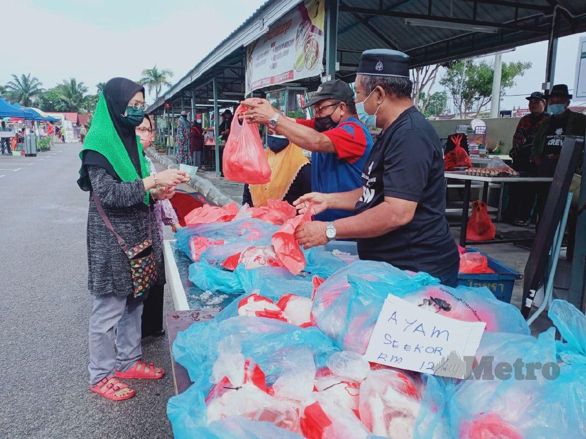 JUALAN amal ayam segar RM12 seekor di Pasar Sunday Masjid Ar-Rahman Kampung Pulai, Serkam, Jasin mendapat sambutan menggalakkan daripada orang ramai. FOTO AMIR MAMAT