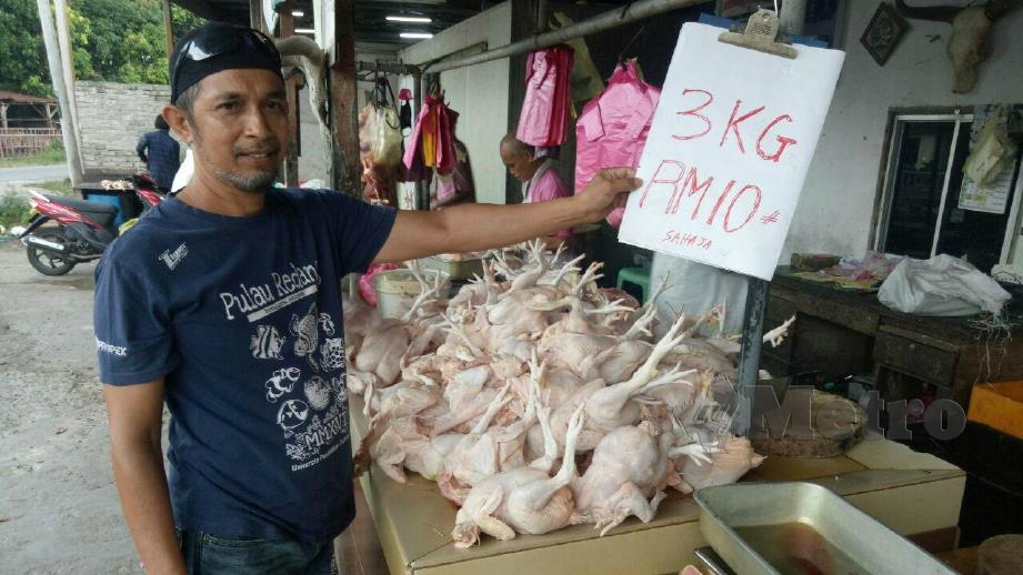 MOHD Zulkifli menunjukkan harga ayam segar pada lelongan di gerainya di Kampung Kubang Parit. FOTO Baharom Bakar