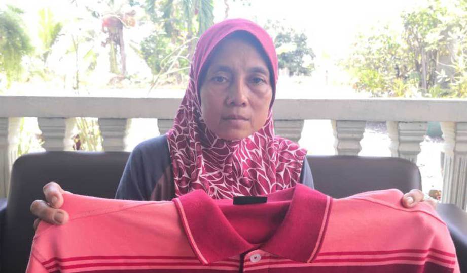 RUSILAH menunjukkan baju yang di belikan suaminya sebagai hadiah hari jadi kepada menantu empat hari sebelum maut dalam kemalangan. FOTO Amirul Aiman Hamsuddin 