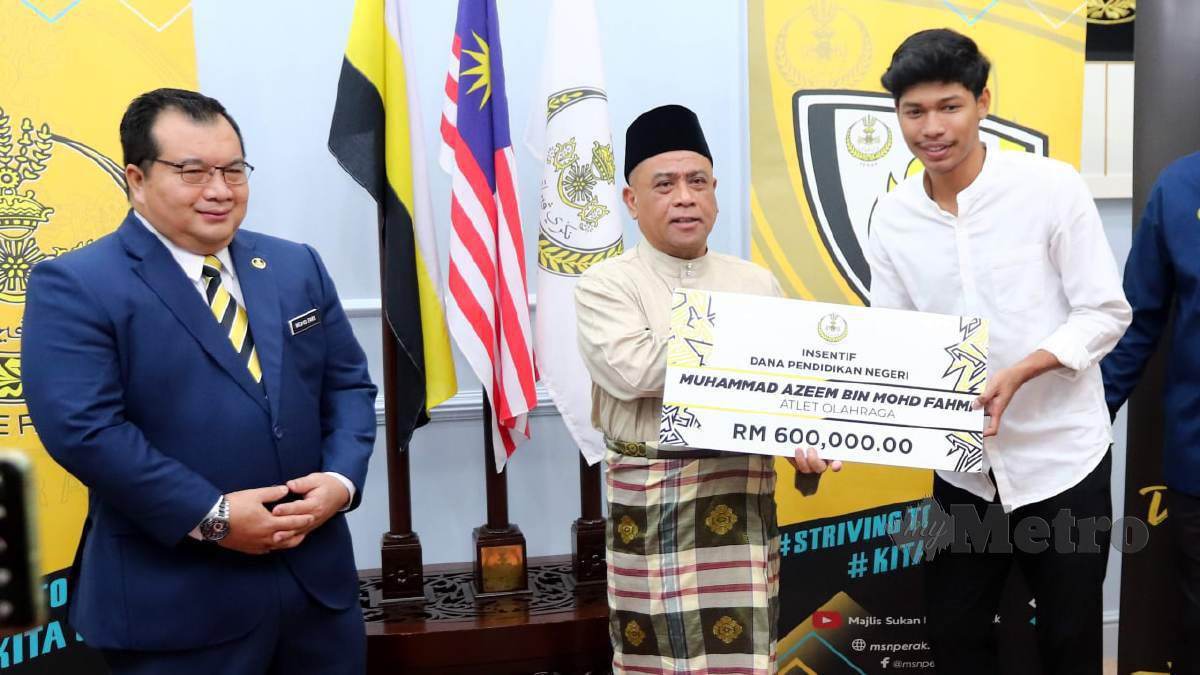 SAARANI (tengah) menyampaikan sumbangan dana pendidikan kepada Muhammad Azeem di Pejabat Menteri Besar Perak. FOTO L Manimaran
