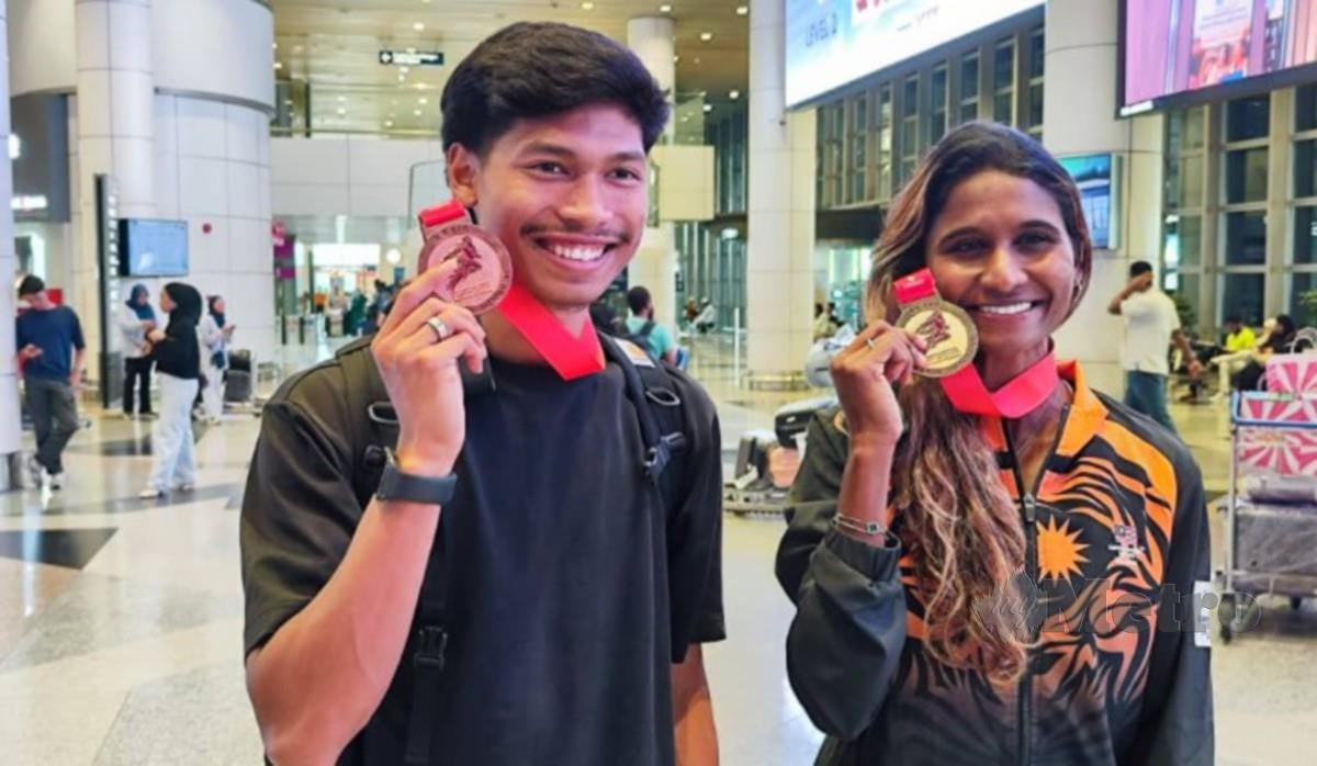 AZEEM (kiri) dan Shereen menunjukkan pingat dimenangi mereka di Terbuka Kazakhstan sebaik tiba di Lapangan Terbang Antarabangsa Kuala Lumpur (KLIA), hari ini. FOTO AIDA ADILAH MAT