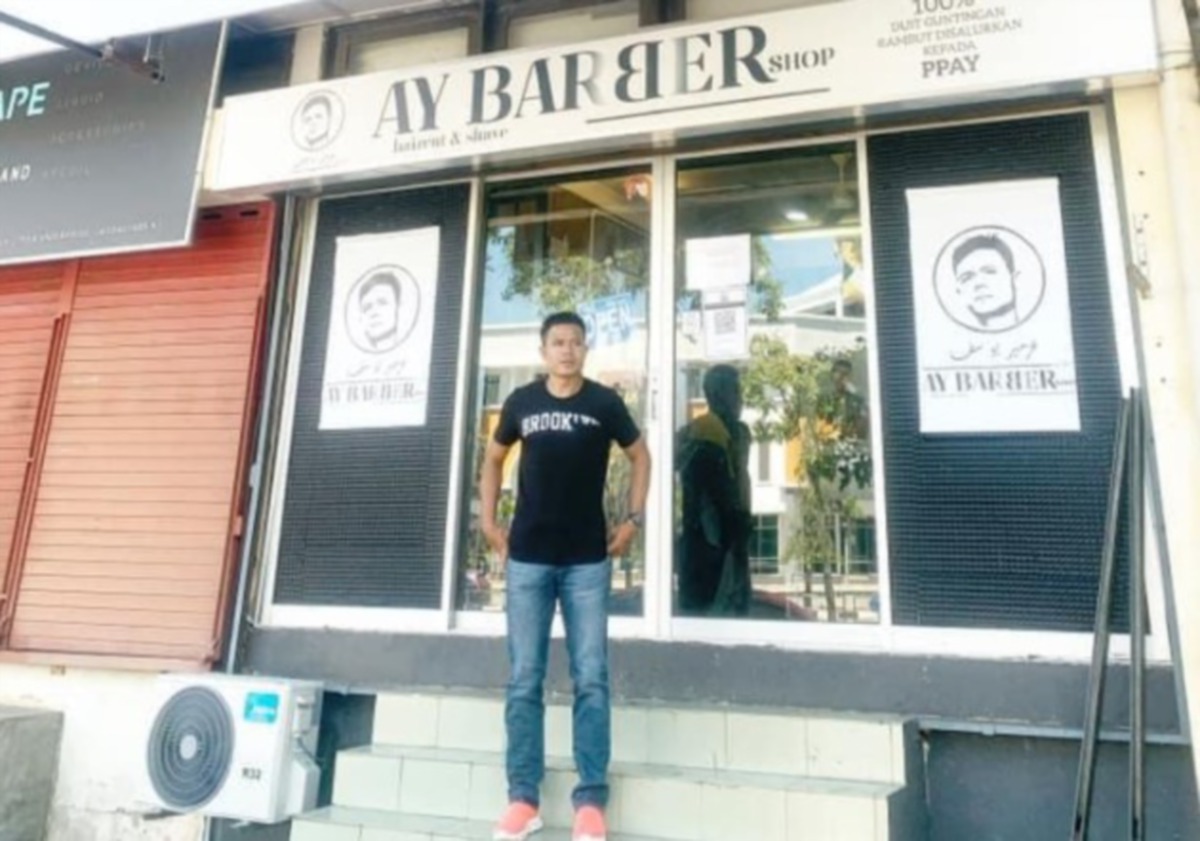 Azmeer di depan kedai gunting rambut AY Barbershop di Kompleks Peruda. 