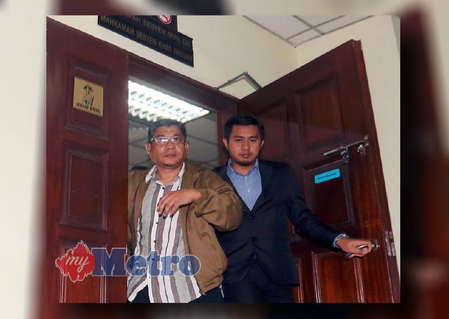 Azman (kiri) diiring keluar daripada Mahkamah Sesyen Khas Rasuah Butterworth. FOTO Danial Saad.