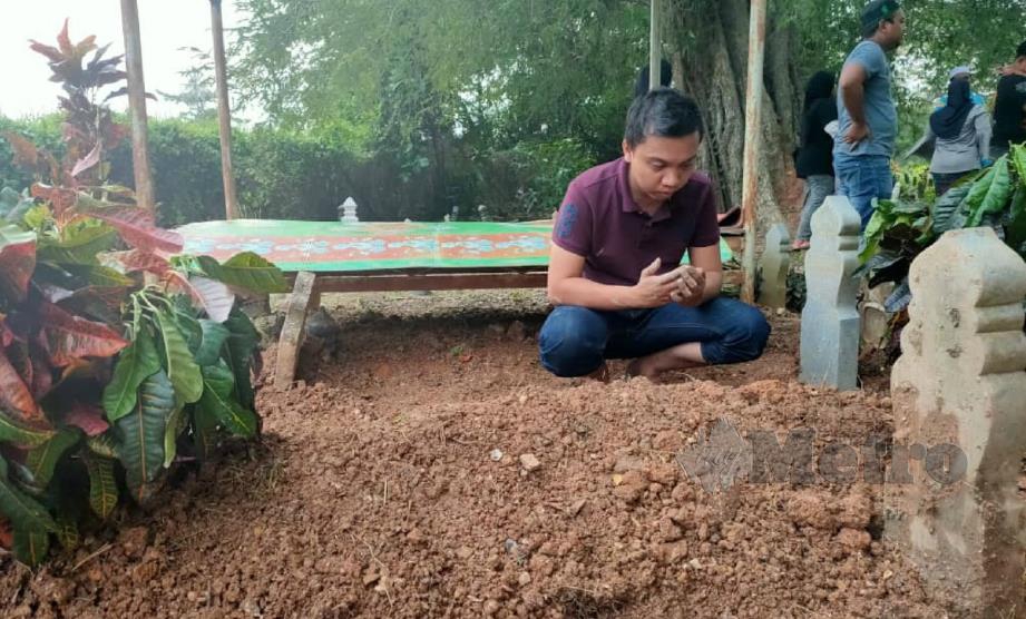 AZMAN berdoa di pusara Salwati di Tanah Perkuburan Islam Kampung Ulu, Kuala Kedah, hari ini. FOTO Zuliaty Zulkiffli. 