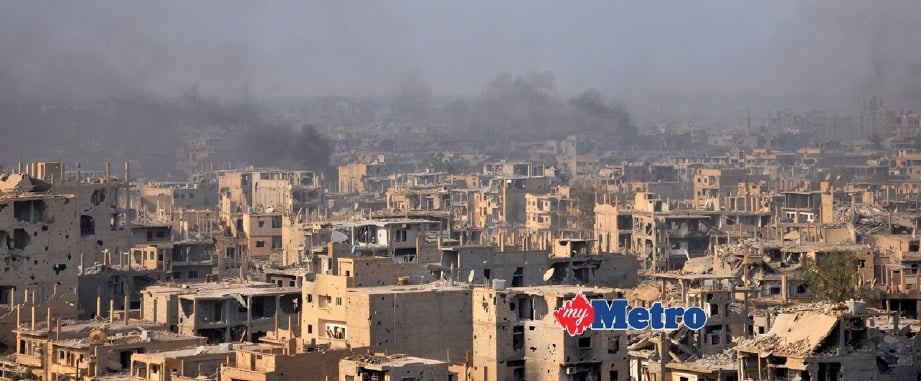Kepulan asap dari bandar raya Deir Ezzor, Syria, ketika tentera kerajaan menawan kubu kuat terakhir IS. Kerajaan Syria mengumumkan bandar raya itu dibebaskan sepenuhnya daripada IS. - Foto AFP 