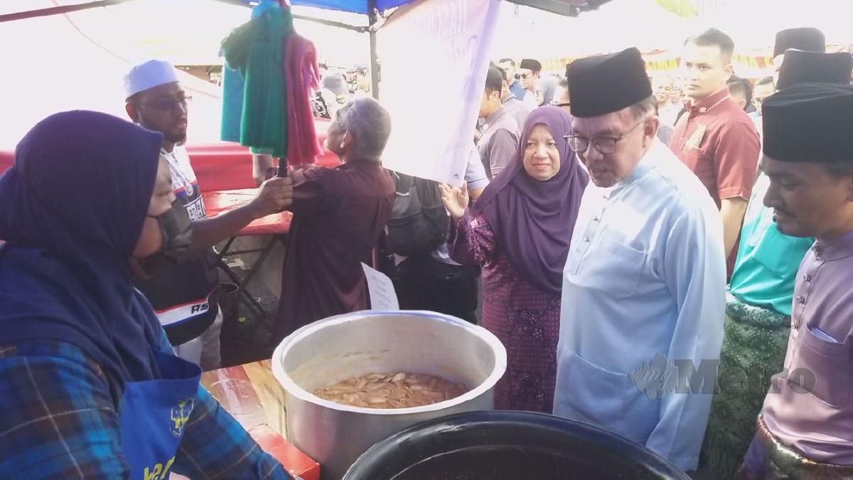 ANWAR beramah mesra bersama beberapa pengusaha gerai di Bazar Ramadan Persiaran Wawasan, Kangar hari ini. FOTO Aizat Sharif