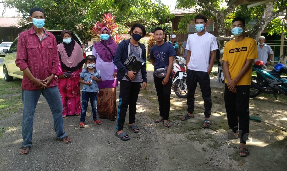 NORHATIJAH (empat dari kiri) bersama Muhammad Azuan (lima dari kiri) dan rakan serta penduduk kampung yang berusaha mencari mangsa malam tadi. FOTO MOHD RASHIDI YUSUF.
