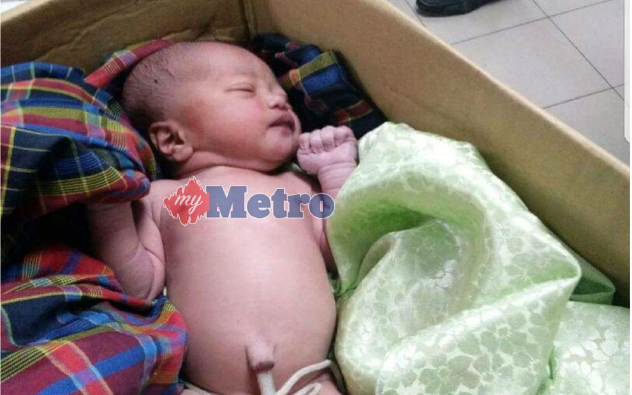 Bayi lelaki yang ditemui ditinggalkan di  dalam kotak di tepi pasu bunga rumah di Jalan Selasih, Kampung Kurnia Jaya, Kamunting, Taiping, hari ini. FOTO ihsan pembaca