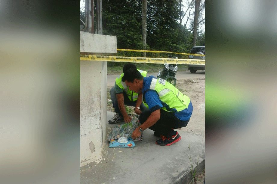 Anggota polis memeriksa mayat bayi yang ditemui berhampiran pondok pengawal terbiar di Taman Bestari, 3 petang hari ini.
