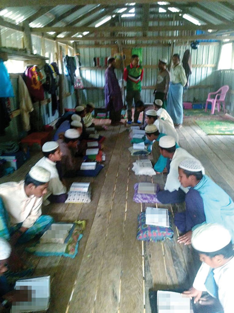 PENDUDUK kampung belajar membaca al-Quran.