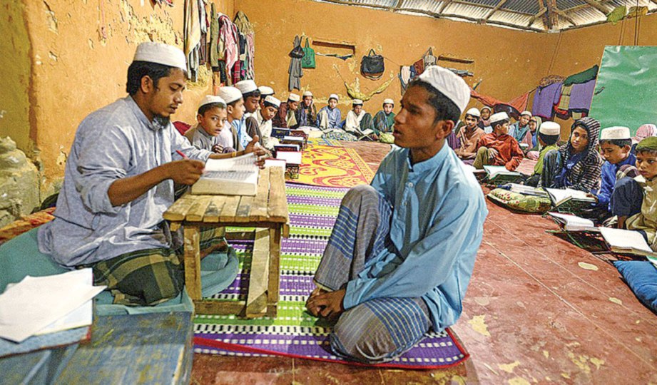 PENDUDUK kampung belajar membaca al-Quran.