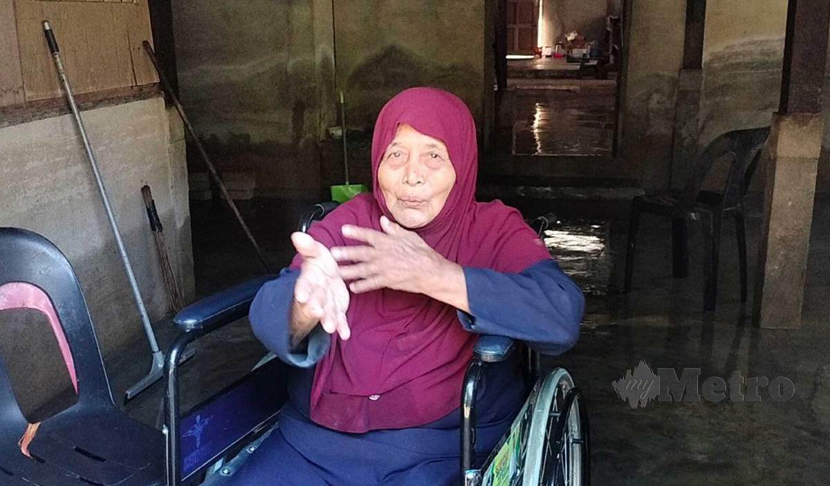 BADARIAH ketika menceritakan pengalamannya diselamatkan oleh anggota APM selepas rumahnya di Kampung Baru dinaiki air malam tadi. FOTO Noorazura Abdul Rahman