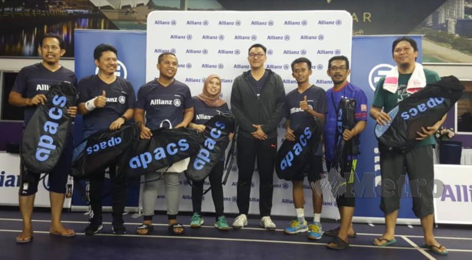 Wang (berdiri tengah) menyampaikan hadiah kepada pasukan Berita Harian / Harian Metro yang menyertai Kejohanan Badminton Media Allianz semalam. 
