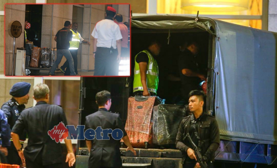 AMAR Singh (kiri) menyaksikan anggotanya memunggah sejumlah bagasi dan kotak dari kediaman di Pavilion Residences Apartment ke dalam trak polis, malam tadi. FOTO Luqman Hakim Zubir