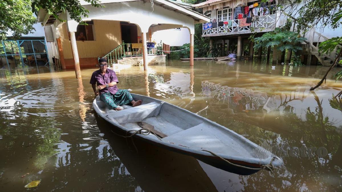 SYED Zainal Abidin menggunakan perahu di halaman rumahnya sebagai pengangkutan utama untuk meredah air di Kampung Terusan, di sini.  FOTO Nik Abdullah Nik Omar.