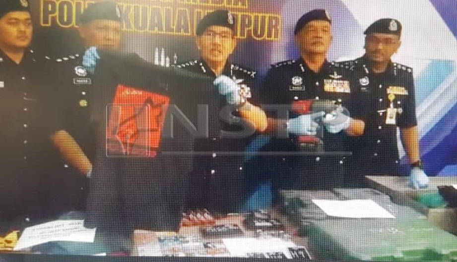 MAZLAN (tiga dari kanan) menunjukkan baju dipakai suspek dalam kejadian belasah dan samun wanita di dalam lif, Khamis lalu, pada sidang media di IPK Kuala Lumpur, hari ini. FOTO Norizuan Shamsuddin.
