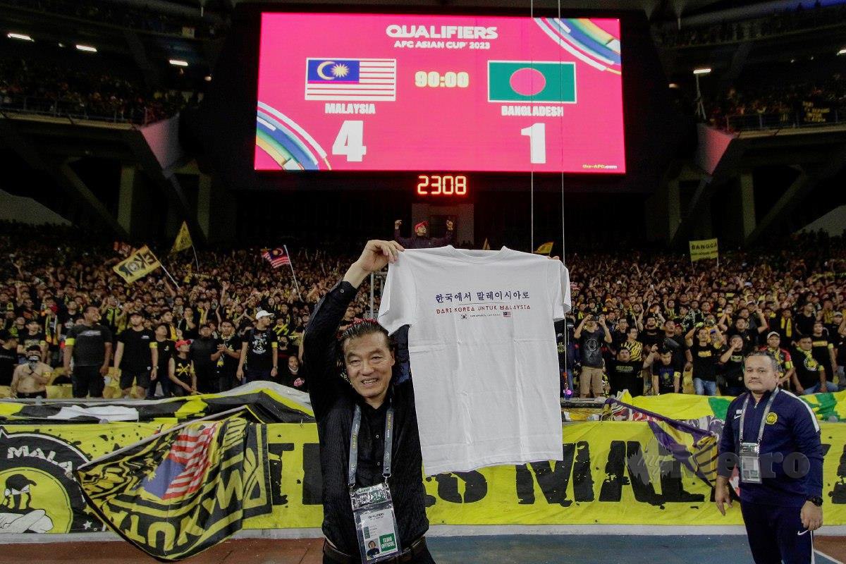JURULATIH Harimau Malaya, Kim Pan-gon menerima sehelai baju tertera perkataan 'Dari Korea Untuk Malaysia' selepas perlawanan malam tadi. FOTO AIZUDDIN SAAD