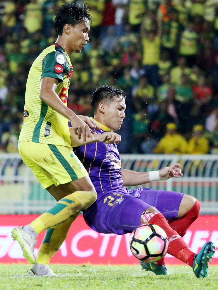 PEMAIN Kedah, Baddrol Bakhtiar (kiri) berebut bola dengan pemain UiTM, Faizal  Ariff pada saingan  di Stadium Darul Aman, malam tadi.