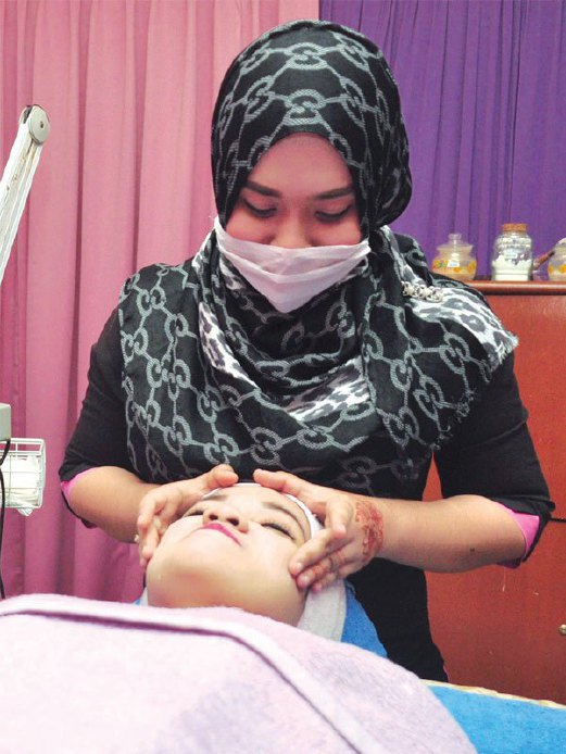 JURUTERAPI Spa Q-Meera melakukan rawatan wajah kepada pelanggannya.