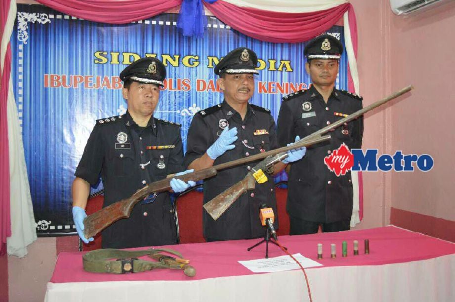 Ahmad (tengah) menunjukkan dua senjata api jenis bakakuk yang dirampas. FOTO ihsan polis