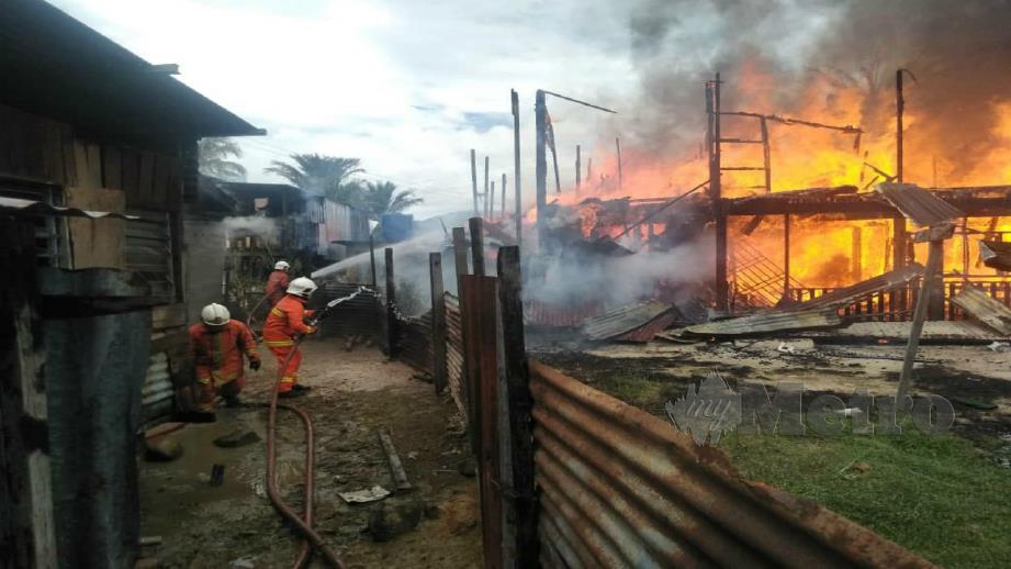 PASUKAN bomba ketika operasi memadam kebakaran di Kampung Durok, Keningau. FOTO JUWAN RIDUAN