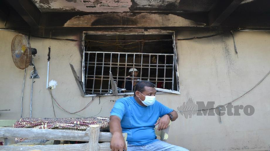 Mohd Nazry di hadapan rumah yang terbakar dan mengorbankan bapanya di Kampung Selamat, Kuantan malam tadi. Foto Asrol Awang