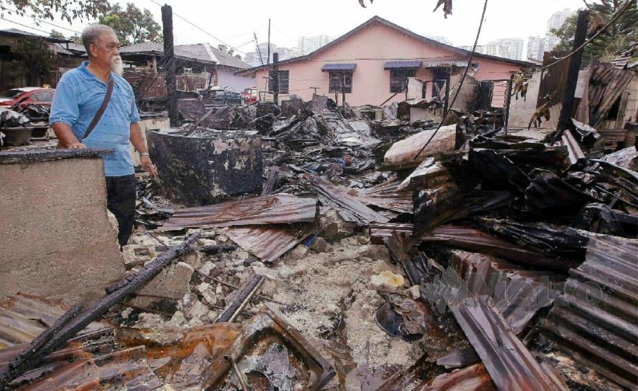 RAZALI melihat rumah keadaan rumahnya yang musnah dalam kebakaran di Kampung Segambut Tengah, Kuala Lumpur, malam tadi.  FOTO SAIFULLIZAN TAMADI.