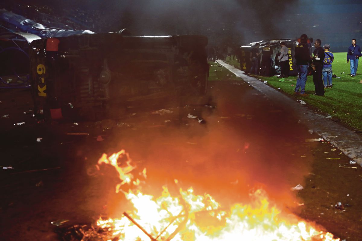 ANTARA kenderaan polis yang dibakar ketika rusuhan berkenaan. FOTO AP 