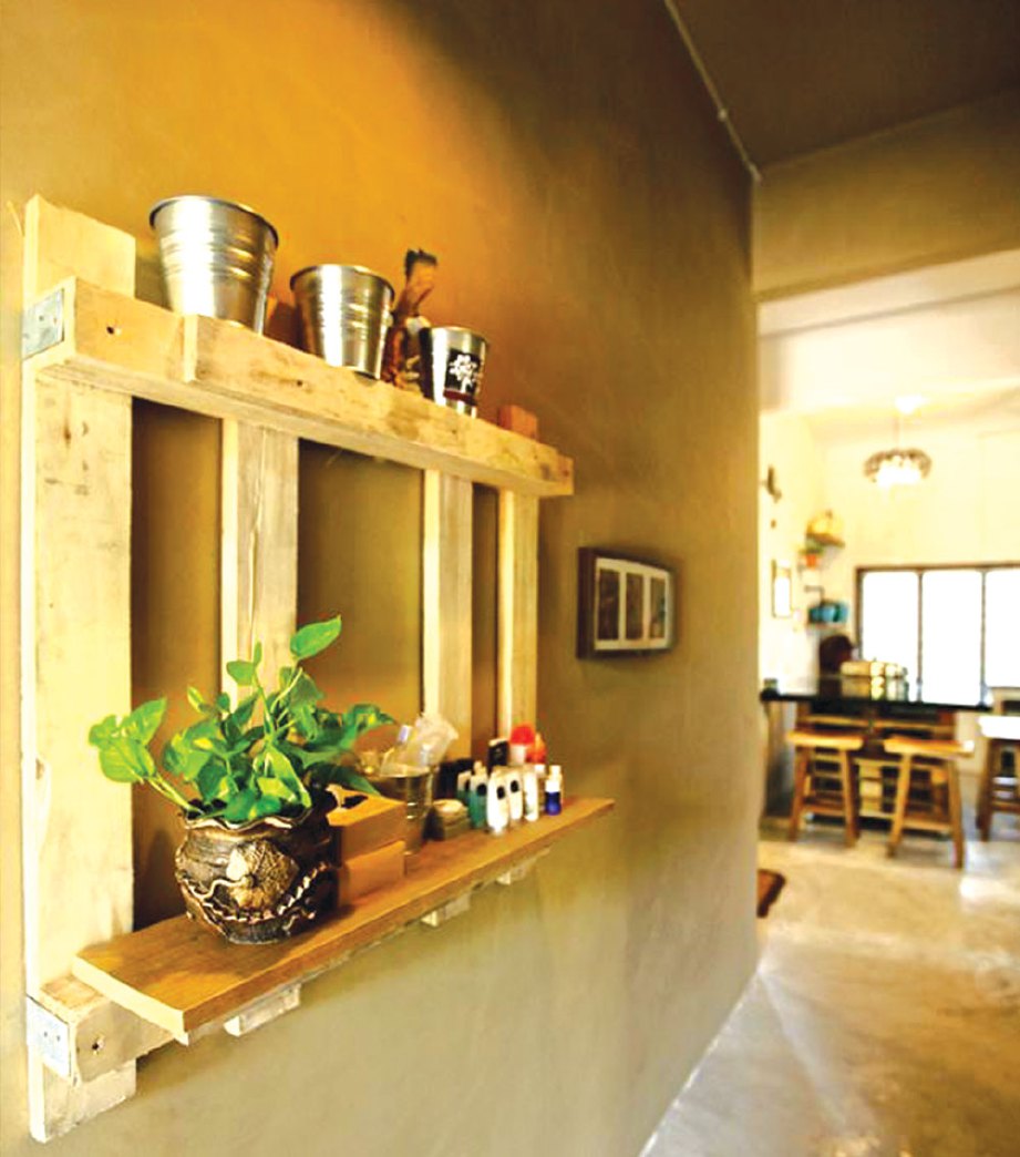 RAK kayu palet dengan hiasan tin lama dan pasu bunga menghias laluan ke dapur.