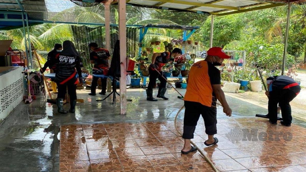 Sukarelawan ResQ Team UPSI bantu mangsa banjir bersihkan rumah. FOTO ihsan UPSI