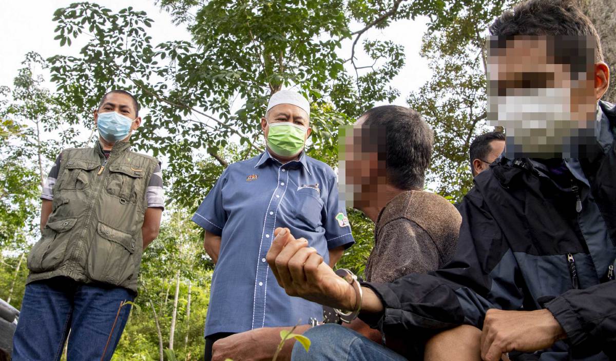 ABDUL Khalim (dua, kiri) bersama Penolong Pengarah Kanan Operasi dan Penguatkuasaan hutan negeri Kelantan Mohd Shukri Aziz (kiri) bertanya sesuatu kepada dua orang lelaki yang ditahan kerana disyaki pembalak haram oleh Jabatan Perhutanan Kelantan di Hutan Simpan Kekal (HSK) Chabang Tongkat. FOTO BERNAMA
