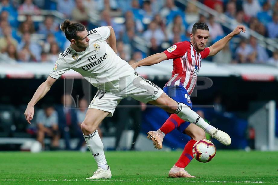 BALE (kiri) berebut bola dengan pemain Atletico Madrid, Koke. - FOTO Agensi