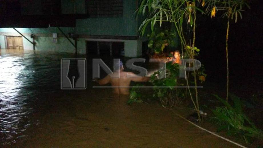 PENDUDUK mengharung air selepas banjir melanda Kampung Tanjung Pari, Siong, Baling, hari ini. FOTO ihsan APM.