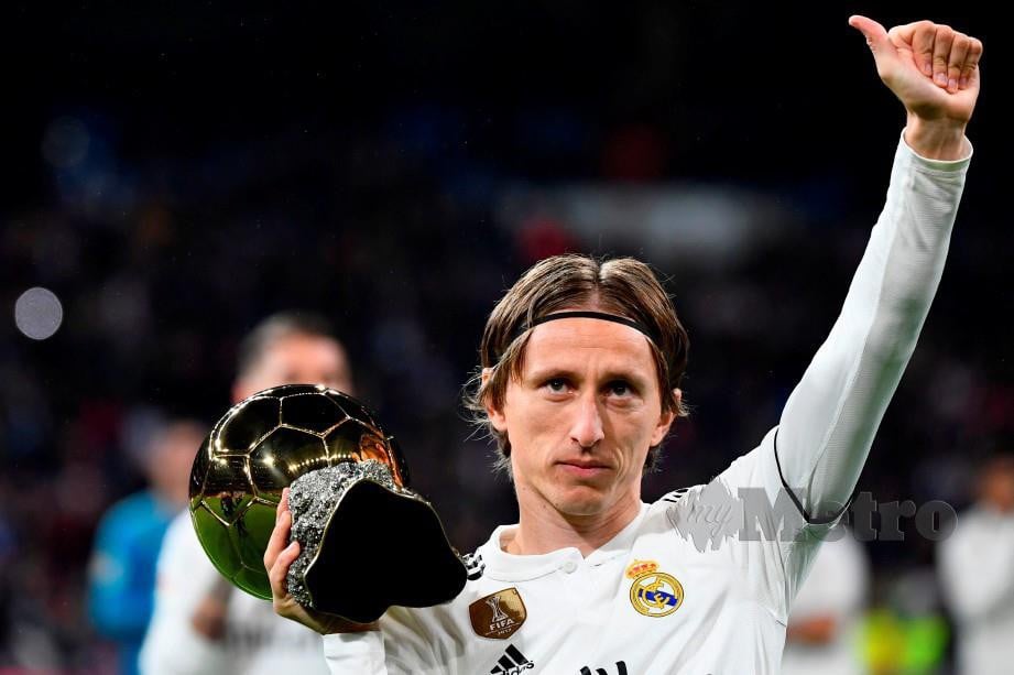 MODRIC memperagakan trofi Ballon d'Or yang dimenanginya kepada peminat di Madrid tahun lalu. — FOTO AFP