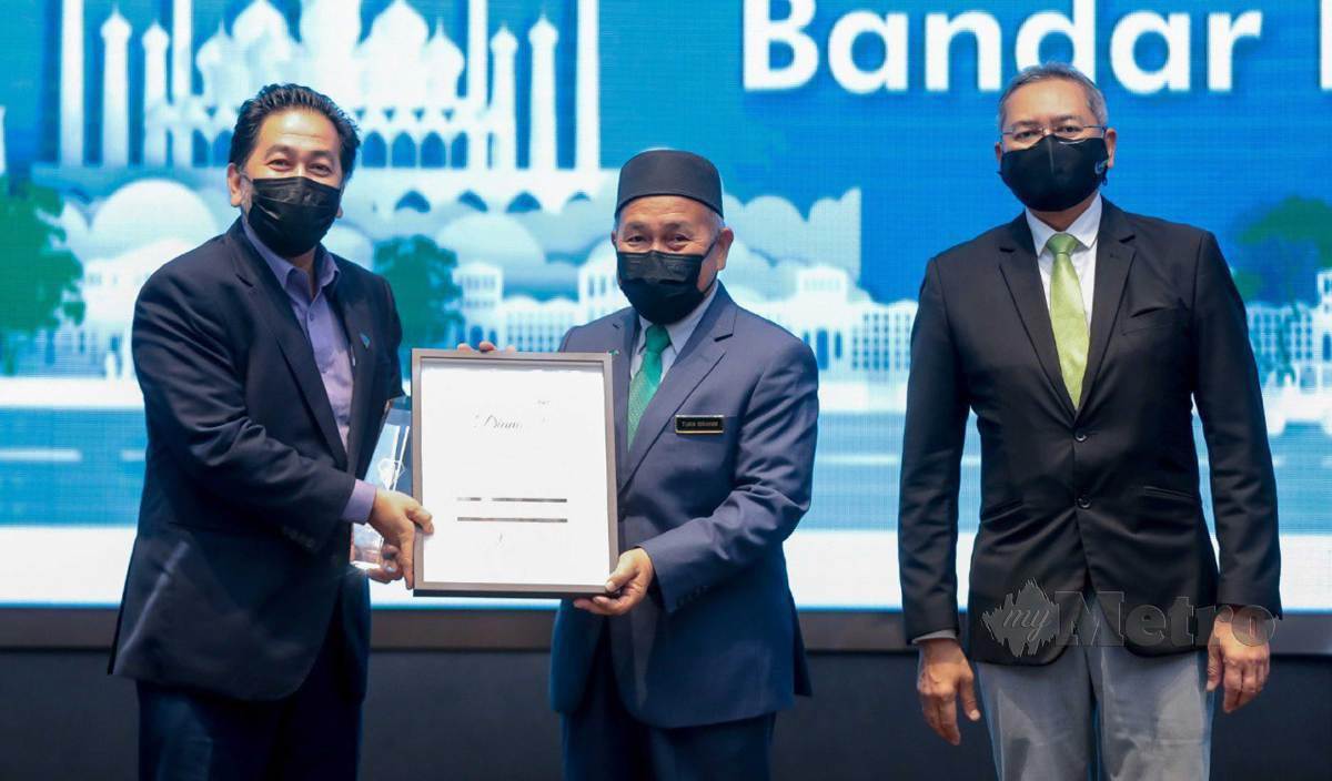 TUAN Ibrahim (tengah) menyampaikan anugerah kepada Datuk Bandar Shah Alam, Datuk Zamani Ahmad Mansor (kiri) pada majlis anugerah bandar rendah karbon 2021 di Hotel EQ. FOTO Asyraf Hamzah