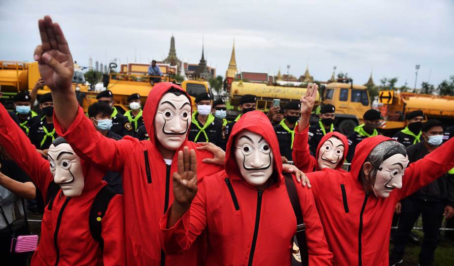 PESERTA demonstrasi menggunakan isyarat tiga jari, yang popular dalam trilogi Hunger Games bagi mendesak peletakan jawatan Perdana Menteri, Prayut Chan-O-Cha. FOTO AFP