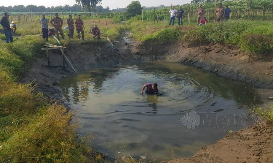 POLIS dengan bantuan bomba mengepam air kolam untuk mengeluarkan motosikal dan kereta sorong mangsa. FOTO ihsan polis.