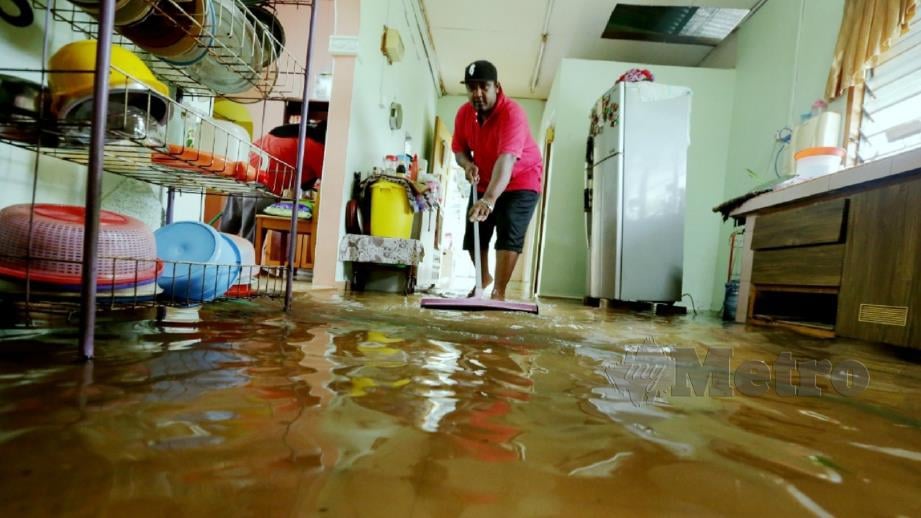 Yuszerin Mat Yunus, 37, membersihkan lantai rumahnya selepas banjir surut di Kampung Bukit Datuk A, Tanjung Minyak. FOTO Khairunisah Lokman