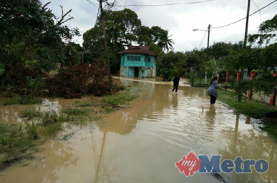 HUJAN lebat menyebabkan kawasan rumah penduduk di Kampung Padang Tembak, Lumut dilanda banjir kilat. FOTO Shahrun Effendi Mohamad.