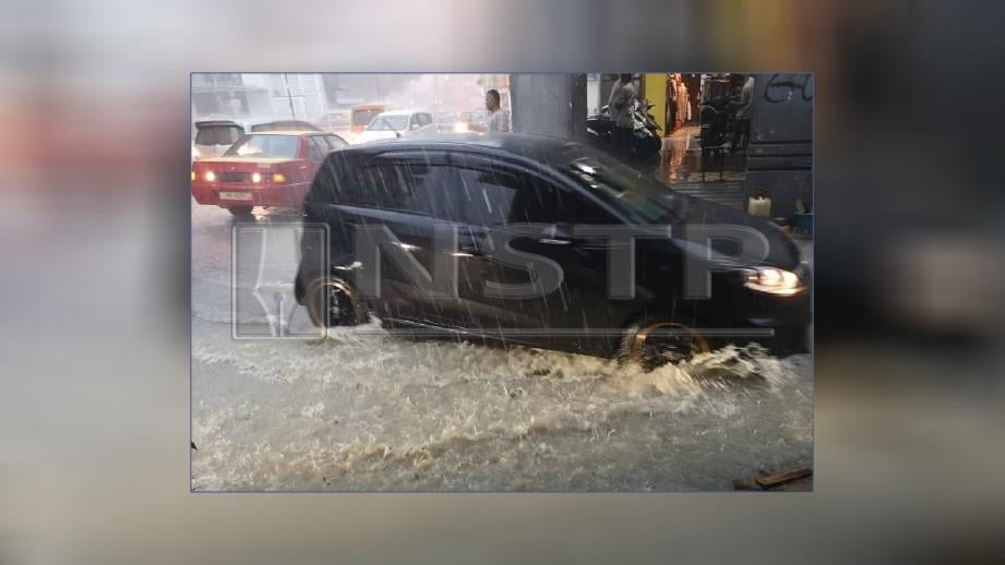 Hujan lebat menyebabkan beberapa jalan di Kuching dinaiki air. FOTO Ihsan Pembaca.