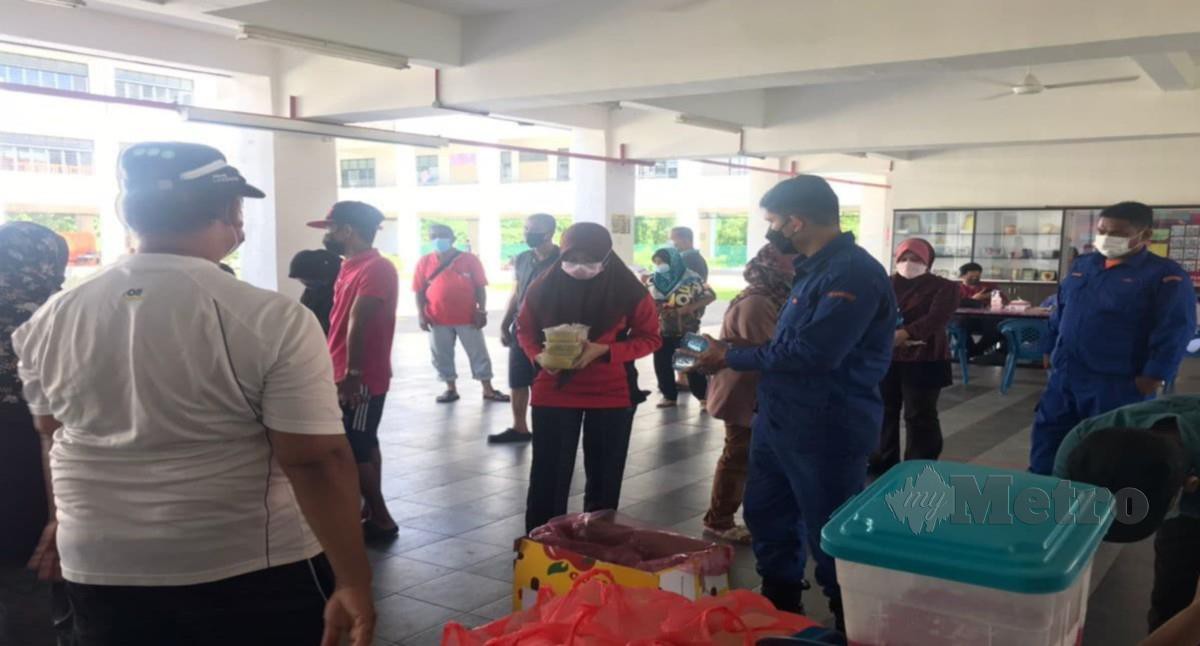 MANGSA banjir di PPS Sekolah Kebangsaan (SK) Taman Merdeka, beratur untuk mengambil makanan. FOTO IHSAN APM