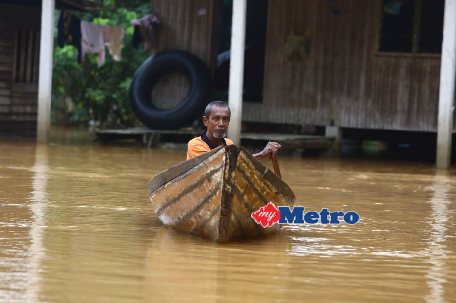 Abdul Halim Yaakob, 56, mendayung perahu selepas rumahnya dinaiki air di Kampung Telar, Hulu Terengganu. FOTO Rozainah Zakaria 