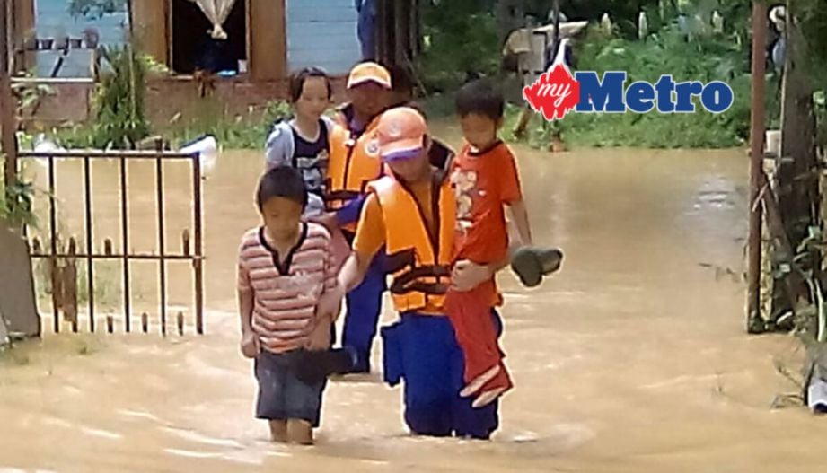 ANGGOTA APM membantu memindahkan mangsa banjir di Kampung Lumantak. IHSAN APM